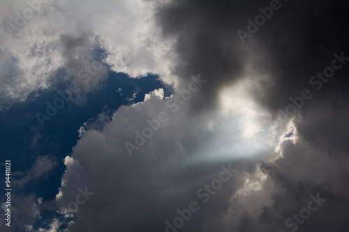 Light rays shine through the dark clouds