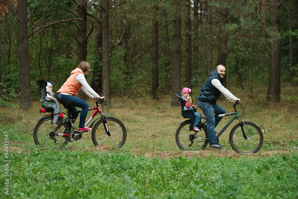 happy family riding bike in wood