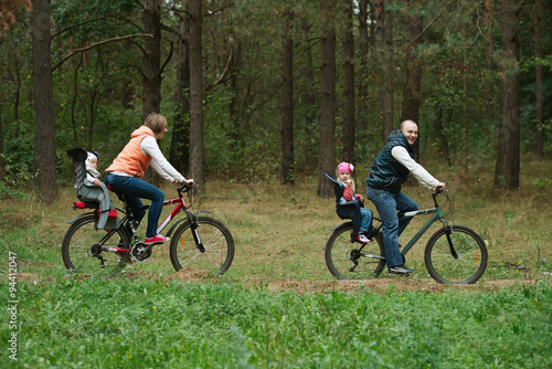 happy family riding bike in wood