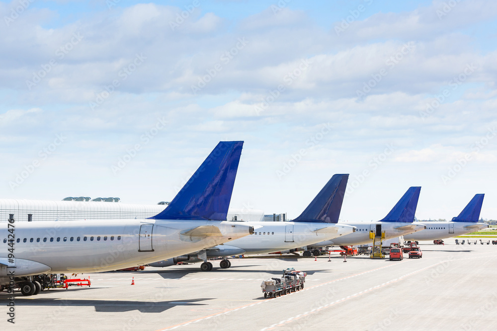 Tails of some airplanes at airport during boarding operation - obrazy, fototapety, plakaty 
