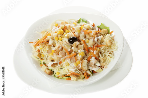 Delicious salad of fresh vegetables with ham, cheese and egg, served in a white bowl. Isolated on white.
