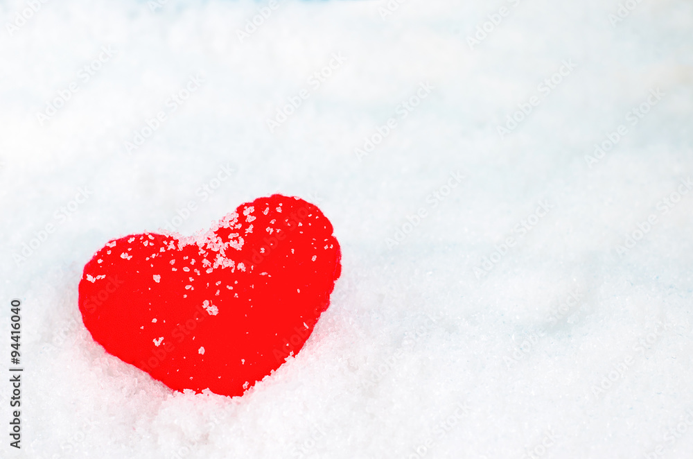Fototapeta premium Red heart shape on white snow