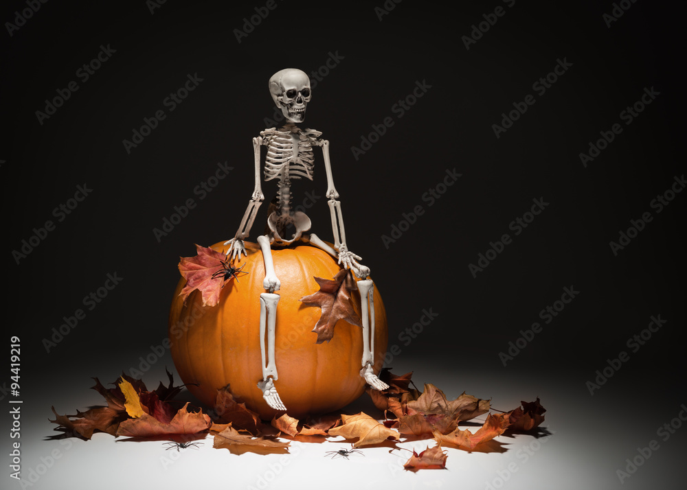 Naklejka premium Skeleton With Pumpkin & Leaves