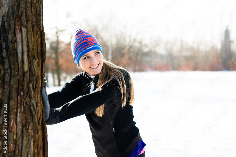 Young woman stretching before winter run