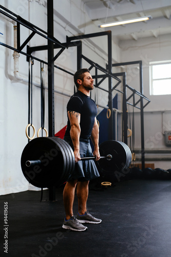 Foto Weightlifter lifting barbells at gym