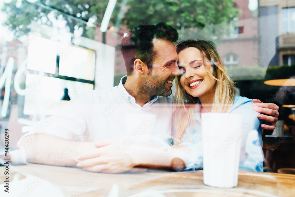 Happy couple hugging at cafe