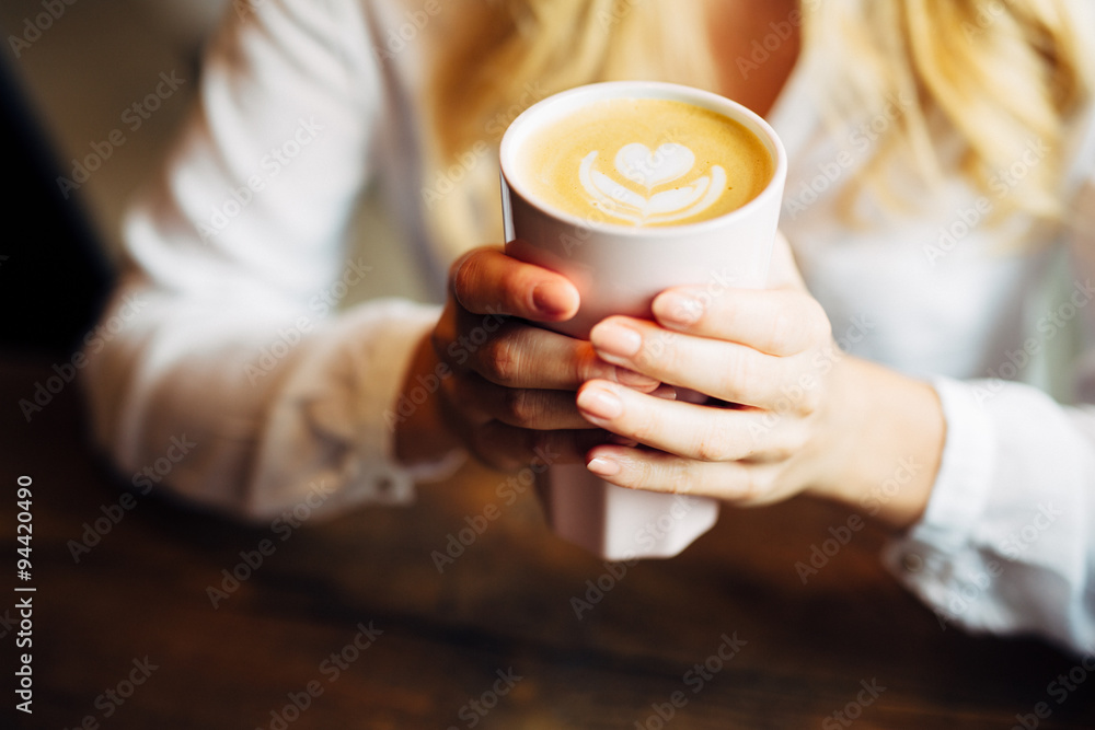 Closeup of woman holding warm latte Closeup of woman holding warm latte