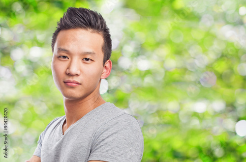 Handsome young asian man crossing his arms and smiling