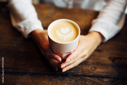 Closeup of woman holding warm cappuccino photo