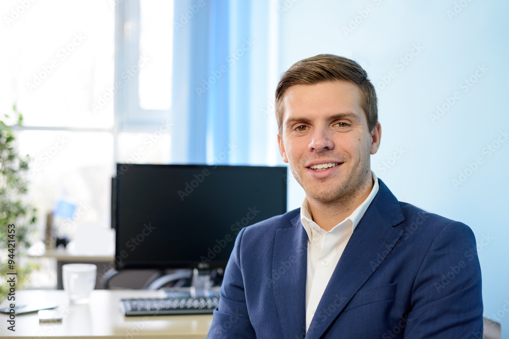 Young Smiling Attractive Businessman in Blue Suit at Modern Office. Business Concept Young Smiling Attractive Businessman in Blue Suit at Modern Office. Business Concept