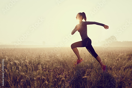 Young woman running during sunset