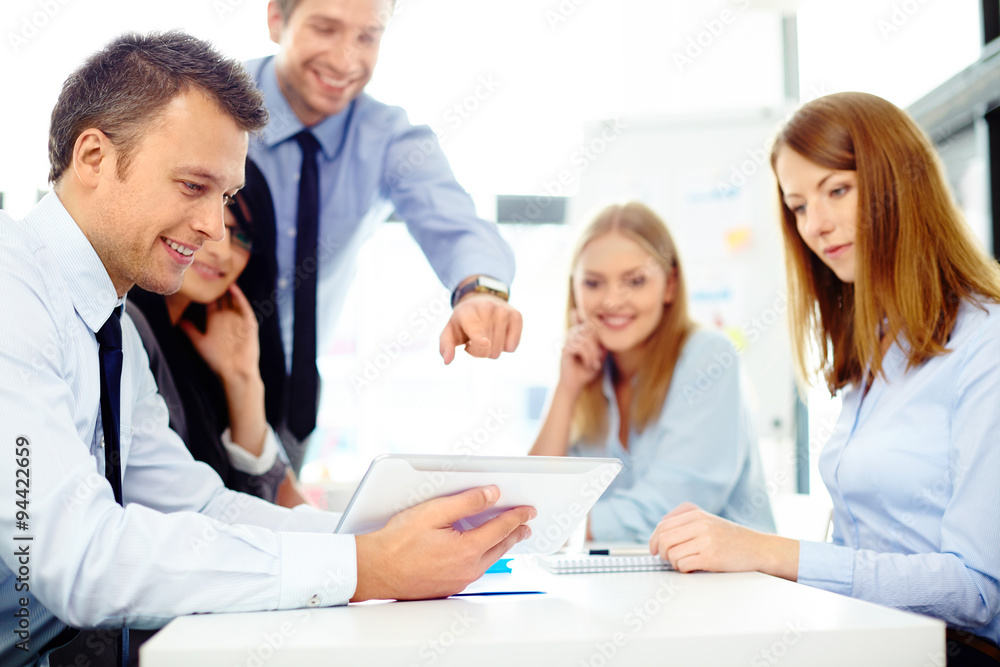 Business people discussing over digital tablet