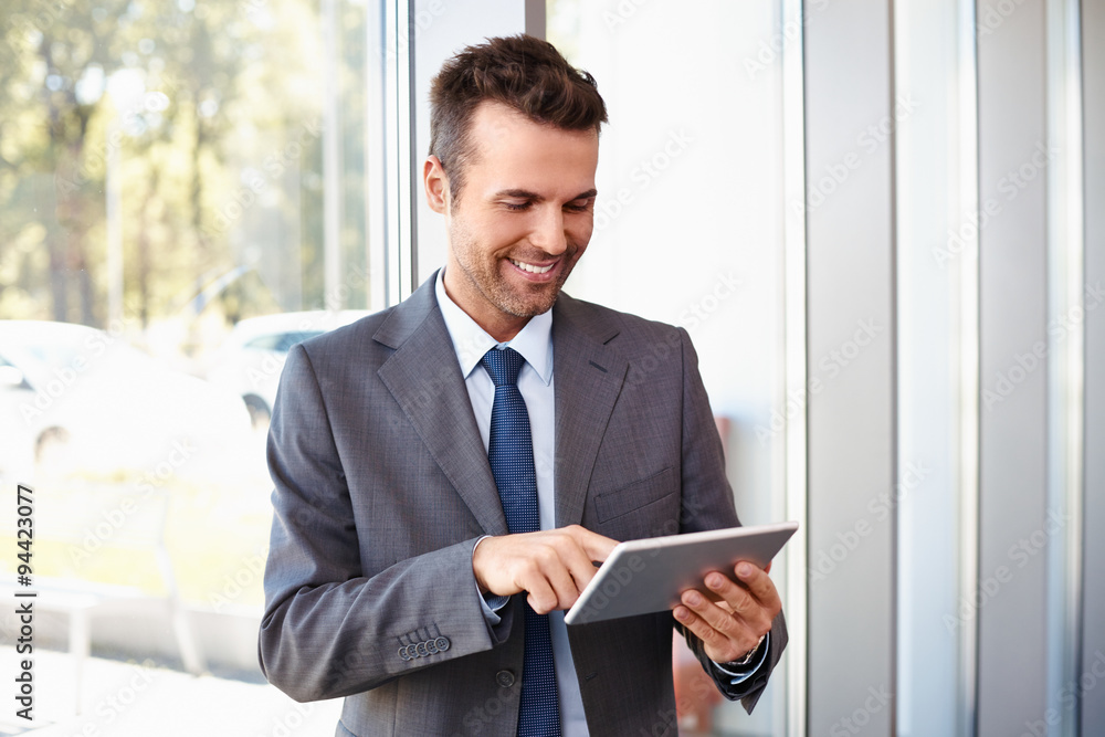 Happy businessman at modern office standing with digital laptop Happy businessman at modern office standing with digital laptop