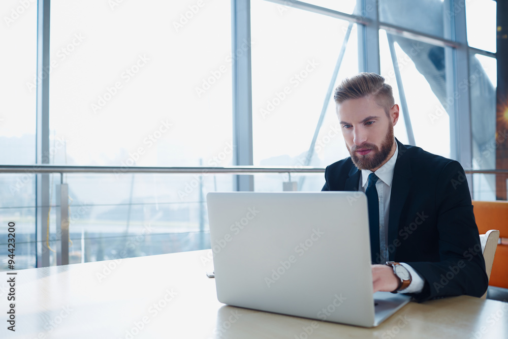 Successful businessman typing on laptop at modern office Successful businessman typing on laptop at modern office