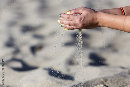 Close-up photo of the woman hands playing with sand © ververidis