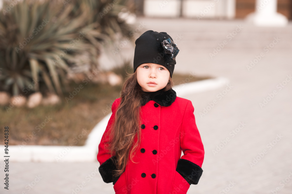 Closeup portrait of cute baby girl posing in winter clothes outdoors.  Stylish child. Looking at camera. Childhood. Stock Photo