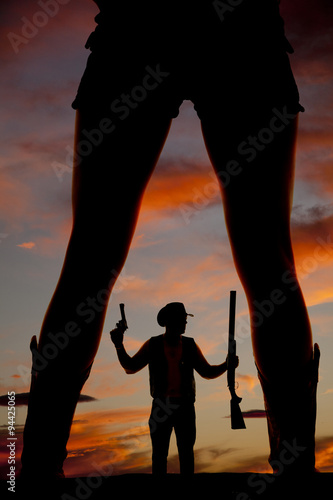 silhouette of a cowboy shotgun in hand pistol up look side betwe