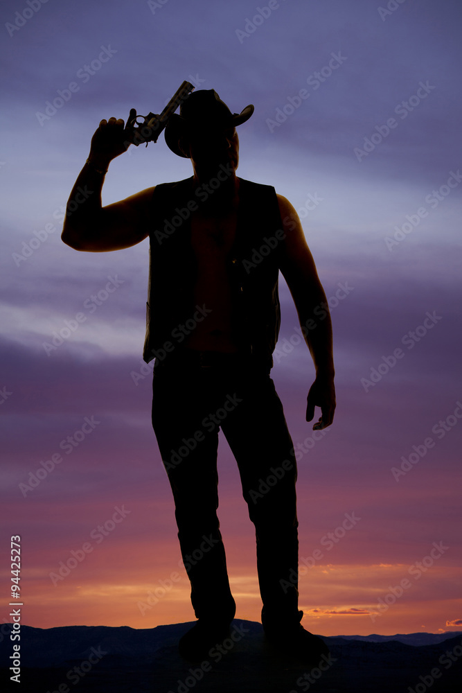 silhouette of a cowboy with a pistol by head