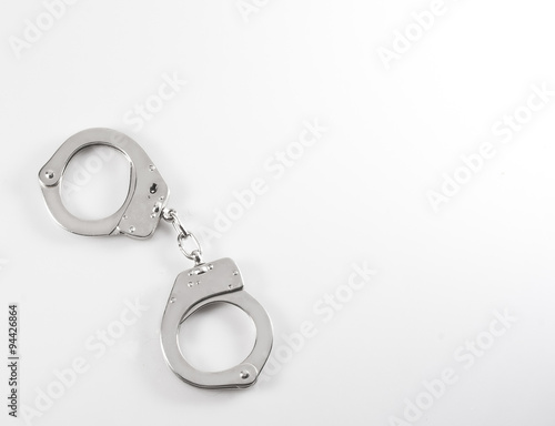 Photo of a pair of handcuffs isolated on a table 