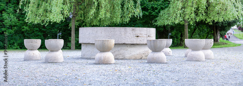 The Table of Silence,crafted from limestone,features twelve chairs arranged in pairs,creating a harmonious and intimate setting. photo