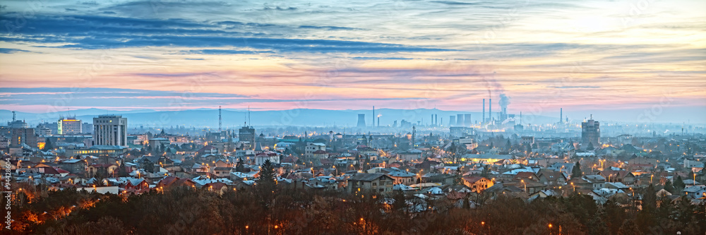 A panoramic view of Ploiesti, Romania, showcasing the city's skyline with a prominent refinery in the backdrop.