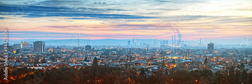 A panoramic view of Ploiesti, Romania, showcasing the city's skyline with a prominent refinery in the backdrop.