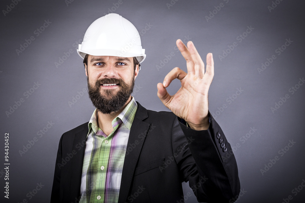 Happy young engineer with white hardhat showing ok sign Happy young engineer with white hardhat showing ok sign
