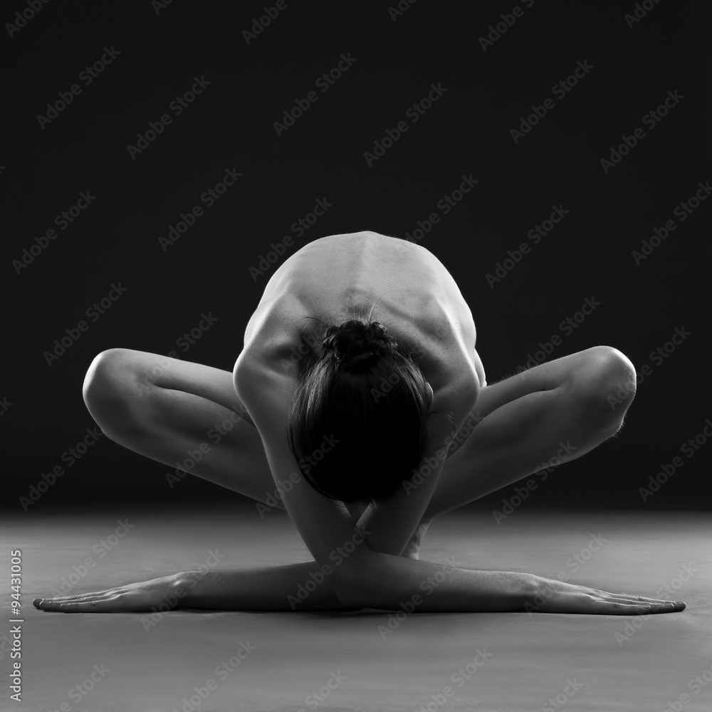 Fototapeta premium Nude yoga. Beautiful sexy body of young woman on black background