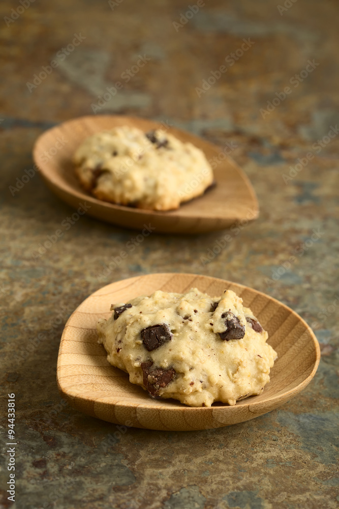 Homemade oatmeal and chocolate cookie on small bamboo plates, photographed with natural light (Selective Focus, Focus on the front of the first cookie) Homemade oatmeal and chocolate cookie on small bamboo plates, photographed with natural light (Selective Focus, Focus on the front of the first cookie)