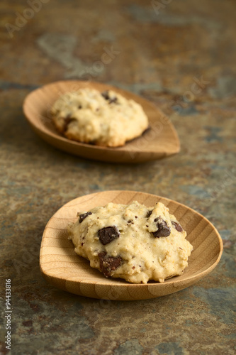 Homemade oatmeal and chocolate cookie on small bamboo plates, photographed with natural light (Selective Focus, Focus on the front of the first cookie)