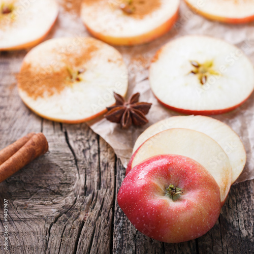 Apples sliced with cinnamon on old wooden background.selective focus.
