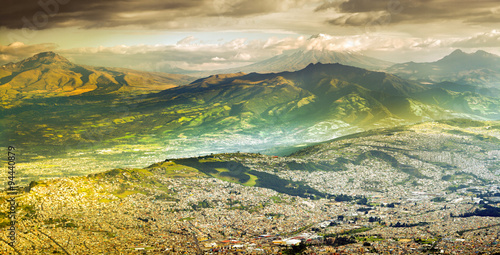 A breathtaking aerial view of Quito, Ecuador, nestled in the Andes mountains. The South American landscape showcases the iconic Cotopaxi volcano and vibrant streets.
