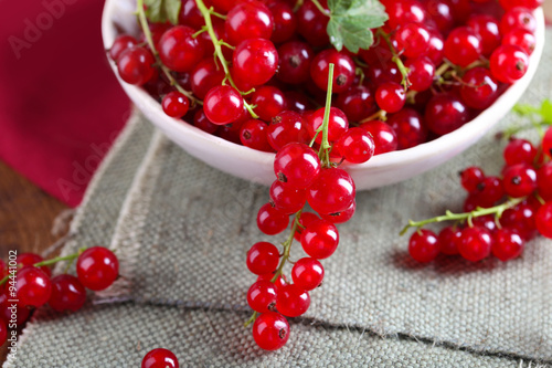 Fresh red currants in bowl on table close up