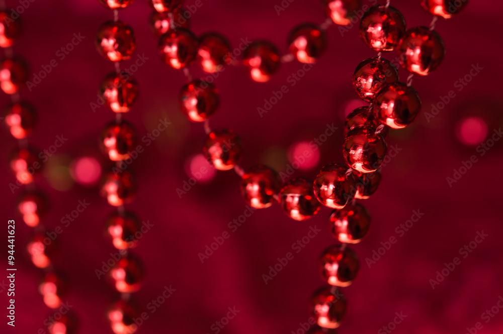 Christmas garland made from small red beads.On A Red Background Christmas garland made from small red beads.On A Red Background