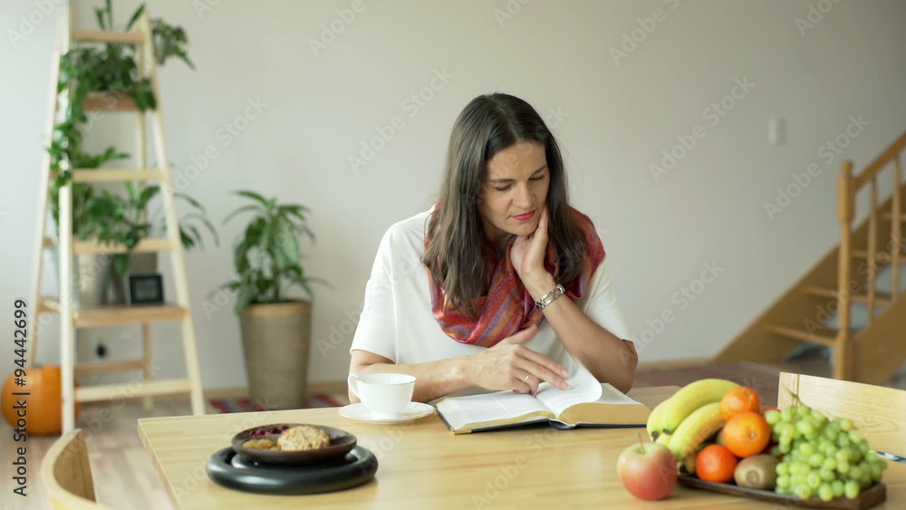 Woman finish reading book and sretching at the table
Woman finish reading book and sretching at the table