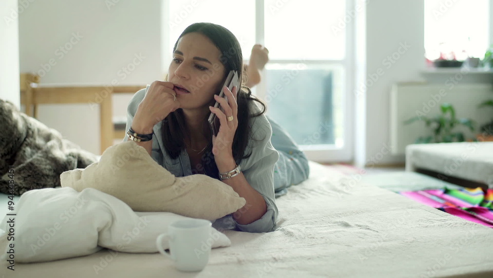Woman calling and receiving bad news while lying on bed
Woman calling and receiving bad news while lying on bed