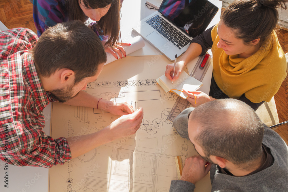 Young group of people/architects discussing business plans. Young group of people/architects discussing business plans.