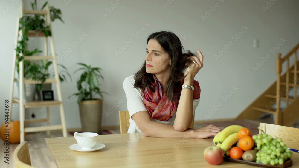 Woman sitting at the table and looking thoughtful
Woman sitting at the table and looking thoughtful