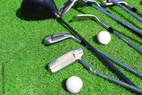 Different golf clubs and balls on golf course