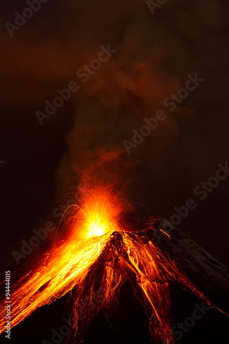 A powerful eruption from the volcano sends dark clouds of magma into the sky, glowing with intense heat and energy. photo