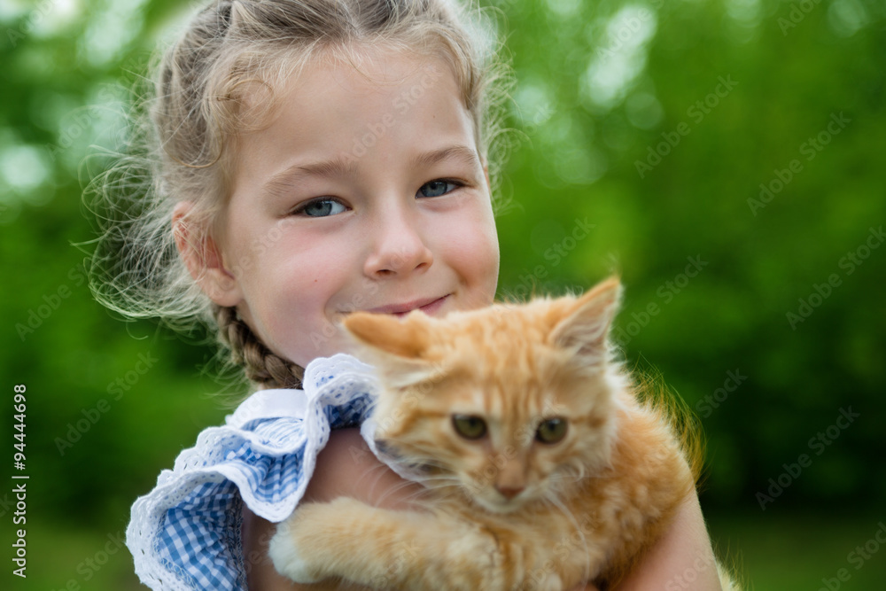 Girl playing with a red kitten in park Girl playing with a red kitten in park