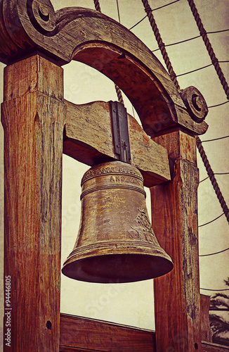 old sailing ship bell on grunge texture photo