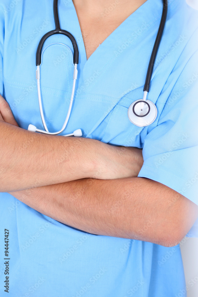 Portrait of unknown male surgeon doctor standing near the wall  in hospital office