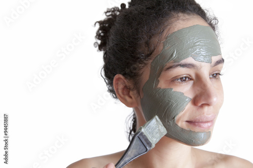 Beautiful young Brazilian model with green clay facial mask