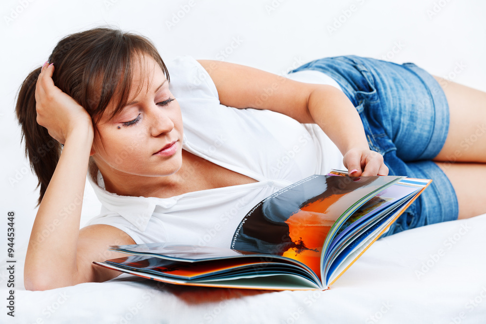 Young woman reading travel magazine