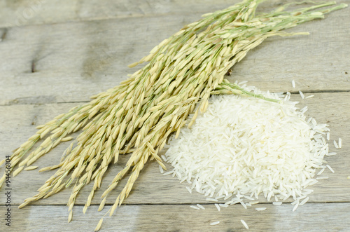 white rice and paddy pile on wood floor