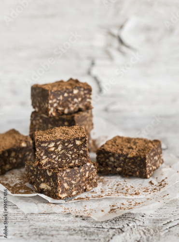 chocolate fudge with cookies and nuts on a light wooden surface