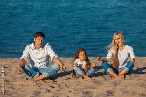 Family at the beach. lotus posture. jeans.