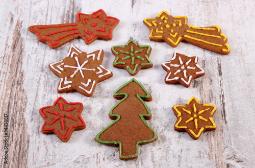 Fresh baked decorated gingerbread on old wooden background, christmas time
