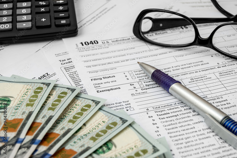 Tax form with pen, glasses, calculator and dollars Tax form with pen, glasses, calculator and dollars